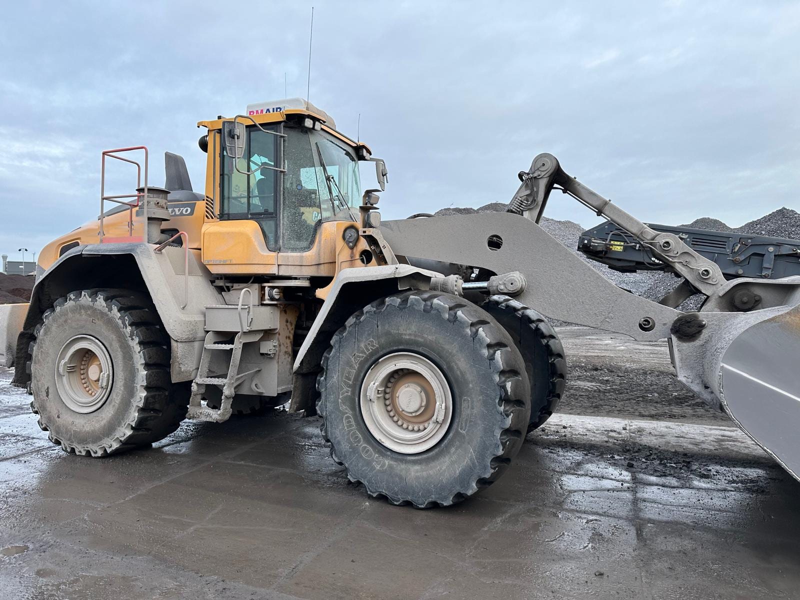 Shovel volledig bedekt met kalkstof, vóór reiniging door MAD Industriële Reiniging
