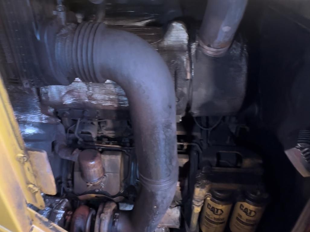 Motorhuis van een CAT 990 vóór reiniging, dichtgeslibd met vet en ijzerhoudende aanslag